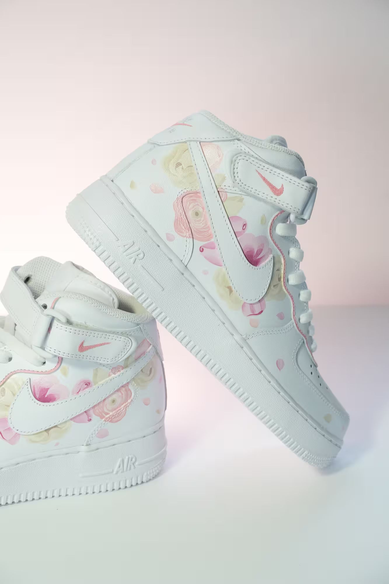 White high-top sneakers with floral pattern on a light pink background