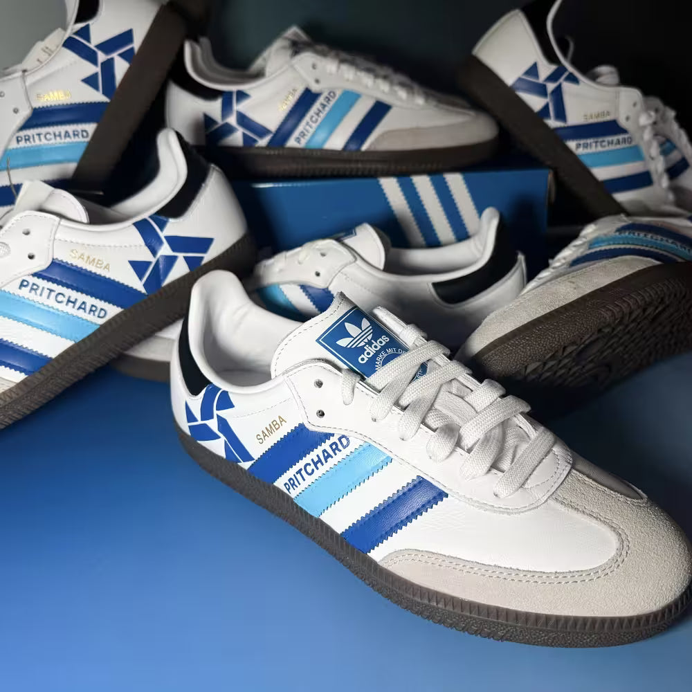 White sneakers with blue and black accents and Adidas logo on a blue background