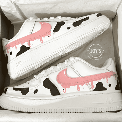 Custom Air Force 1 sneakers with a cow print pattern, predominantly white with black and pink accents