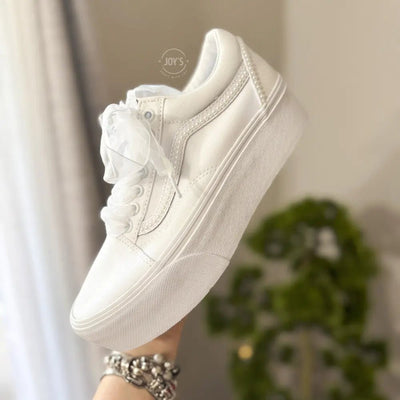 White platform Vans wedding sneakers with pearl trim, satin ribbon laces, and personalized “Mrs.” and last name with wedding date printed on the heels, shown in a rear view