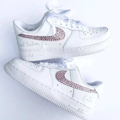 Custom white Nike Air Force 1 sneakers with pink rhinestone swooshes, “Sweet Sixteen” text on the heel, and personalized name “Kate,” shown as a matching pair.